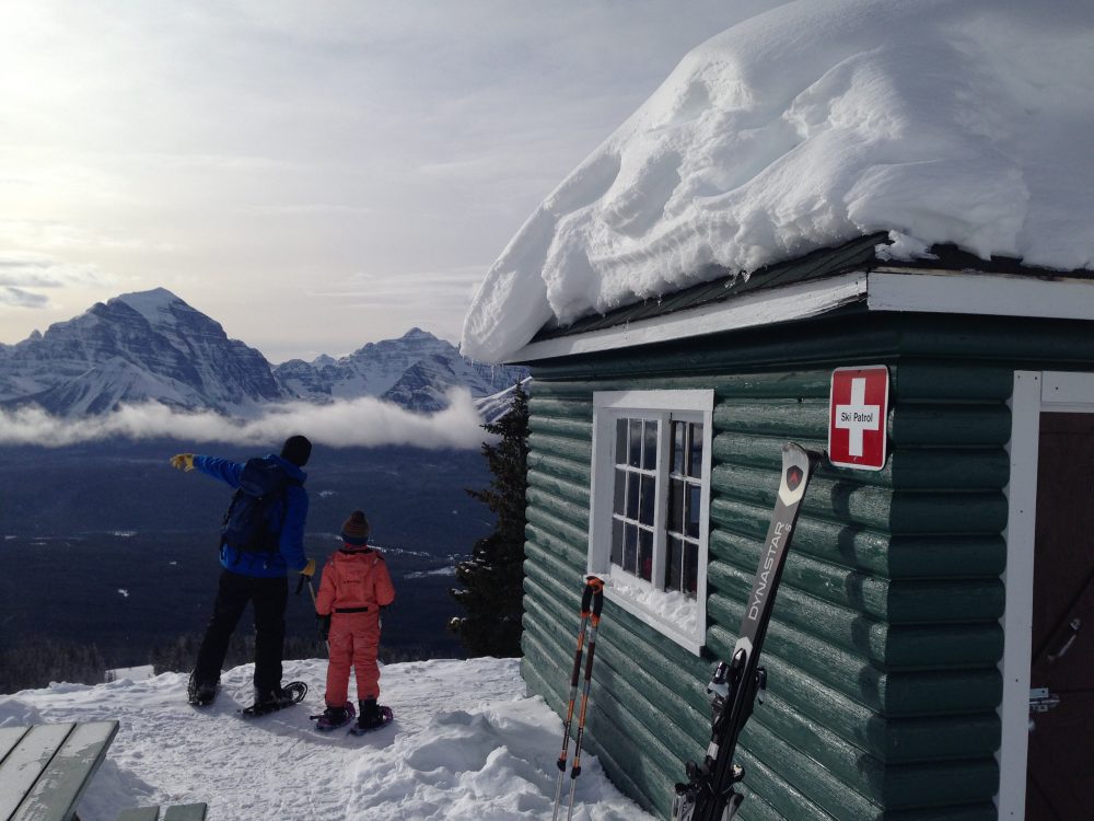woman and son looking at lake while snowshoeing at ski resort