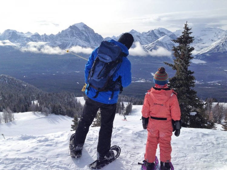 man and child looking at the view while snowshoeing