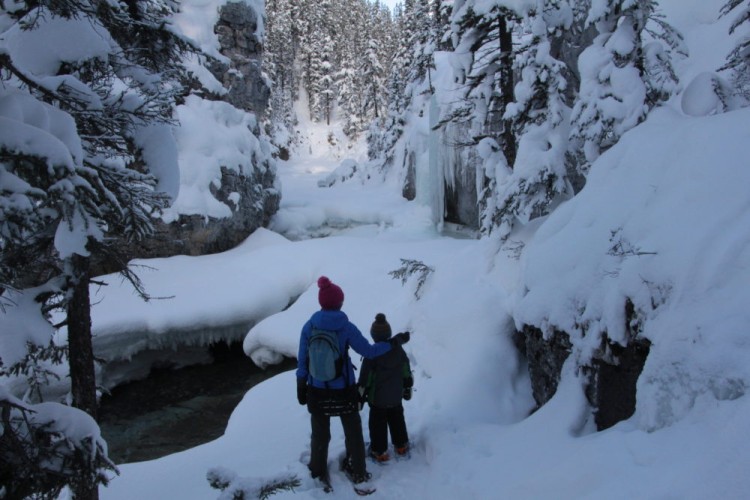 mother and son looking at snow covered scenery at Mosquito Creek Hostel (trees and water)