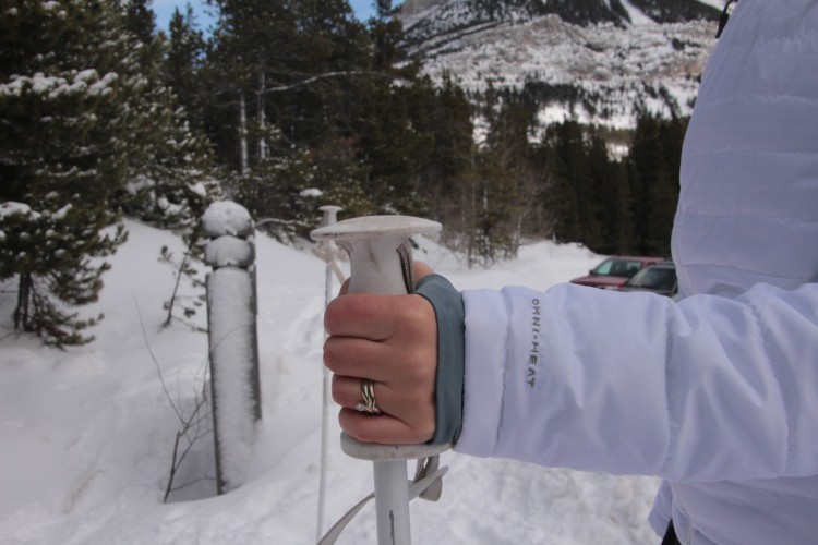 close up of thumb loops on jacket while gripping pole in snow