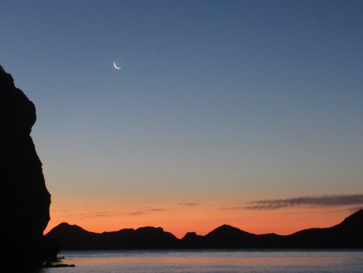 Crescent moon over the mountains and water at sunset near Loreto, Baja California Sur