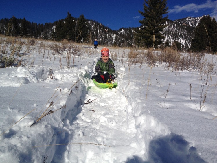 child sledding on snow track