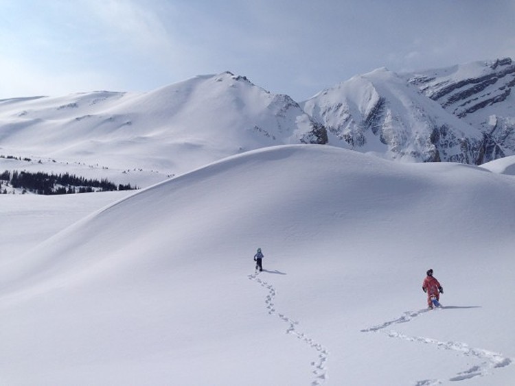 two children walking up snowy hill