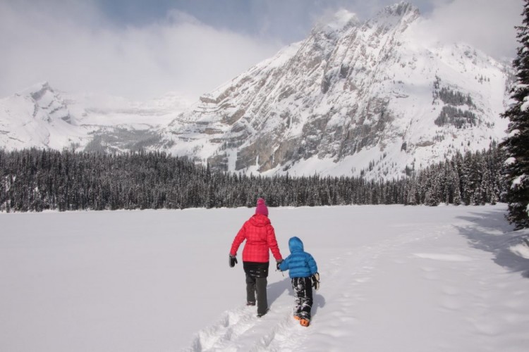 adult and child snowshoeing in deep powder