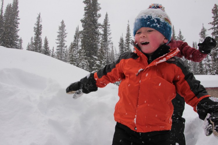 snowshoeing is not boring: child having fun on snow while father is chasing him