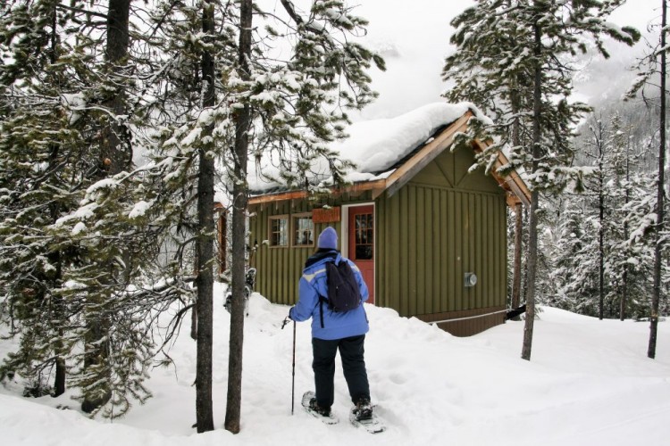person snowshoeing near cabin