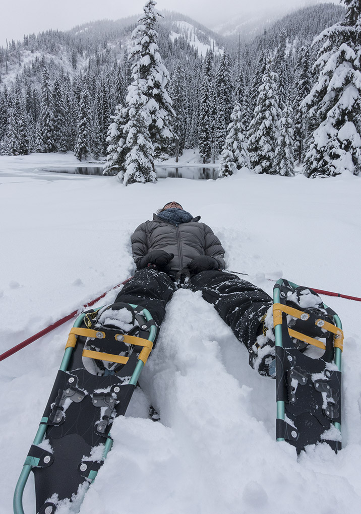 laying in snow on snowshoes