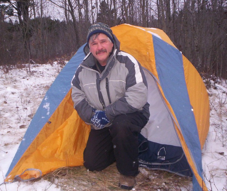 author Jim Joque getting out of tent surrounded by snow