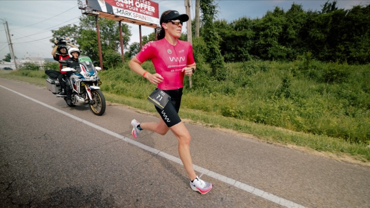 Jackie Hering racing on the road with motorcycle in background