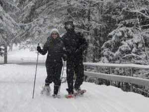 A snowshoeing couple enjoying fresh snowfall at Lapland Lake.