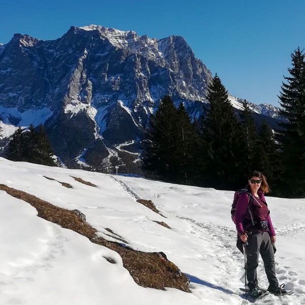 snowshoer facing camera with mountains (Alps) in the background