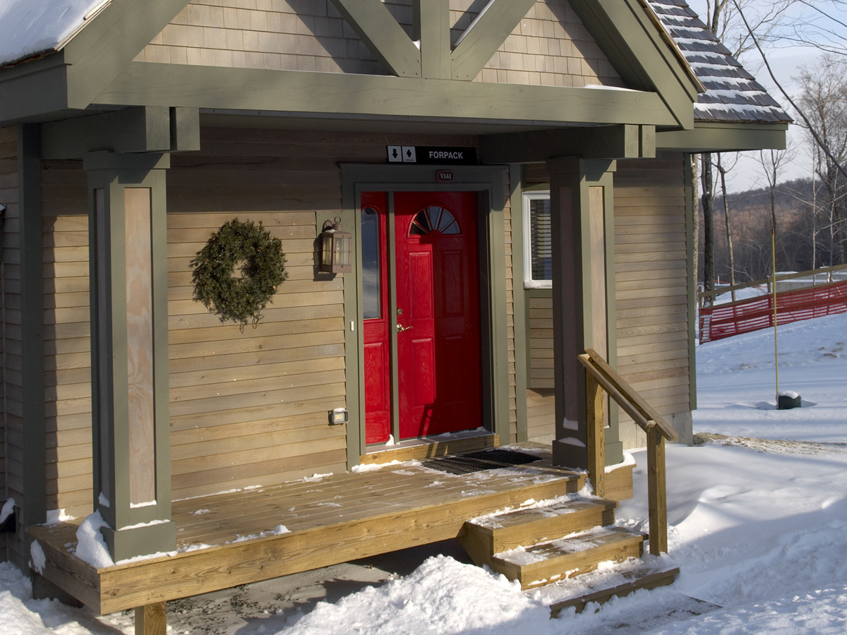 cabin in snow with wreath on the front door