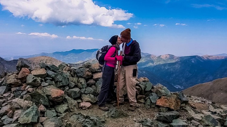 couple at top of New Mexico mountain after hiking under blue sky