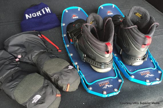 flat lay of snowshoes, boots, gloves, hat