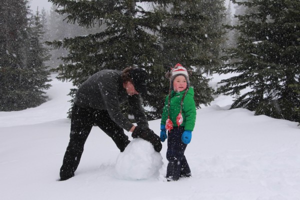 adult and child making a snowman in snow near Hilda Creek Hostel