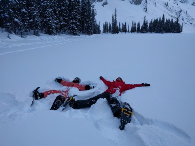 hiking with kids: adult and child laying in snow making snow angels