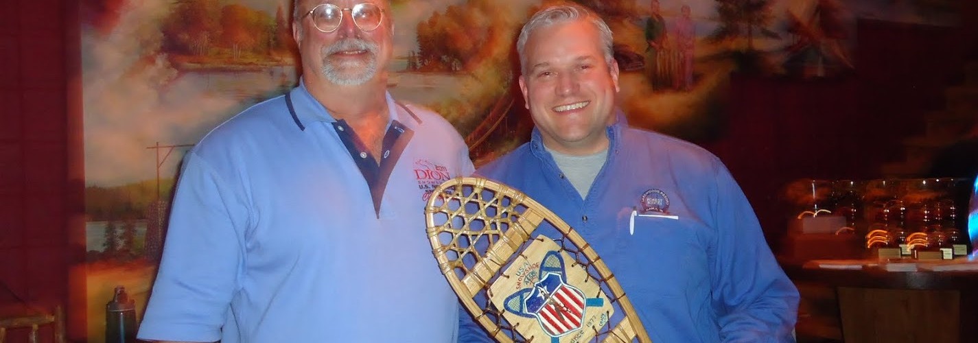 two men holding snowshoe award