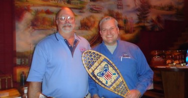 two men holding snowshoe award