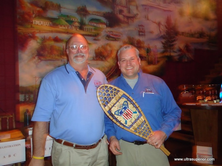 two men holding snowshoe award