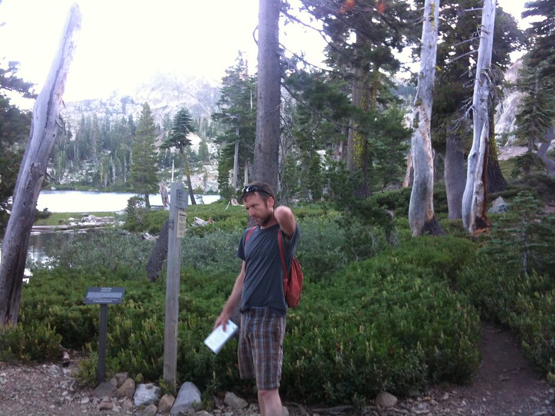 man in woods swatting mosquito