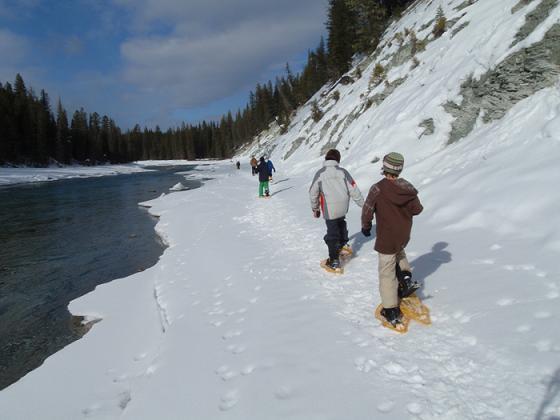 group of snowshoers walking along the river