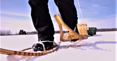 focus on feet in traditional wooden snowshoes