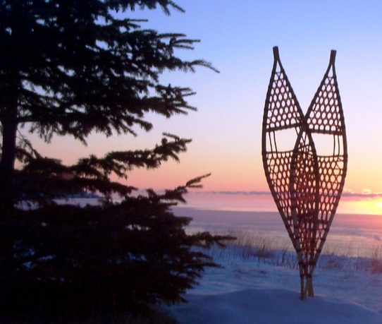 traditional snowshoes in front of a sunset