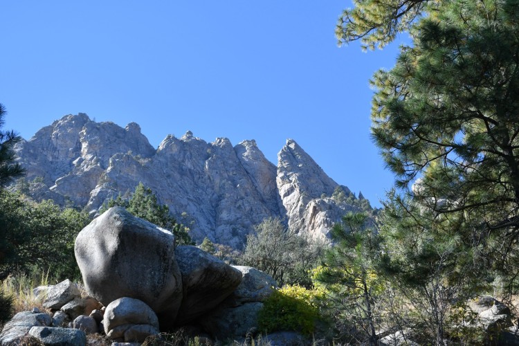 hiking New Mexico mountains: rocky mountain under blue sky with tree to right