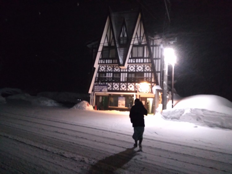 person standing in the snow outside of a hotel