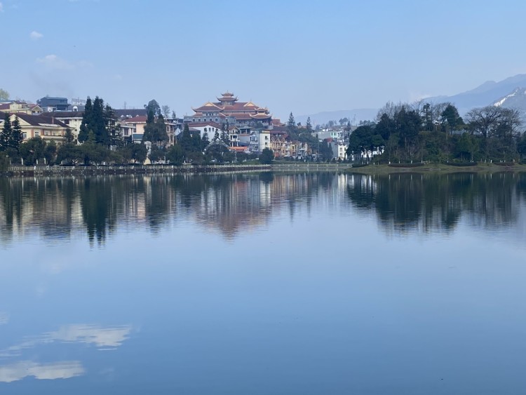 snow in Vietnam: lake with city and temple in background and blue sky above