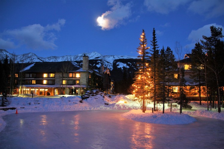 Pomeroy Lodge at night with frozen pond and Christmas lights