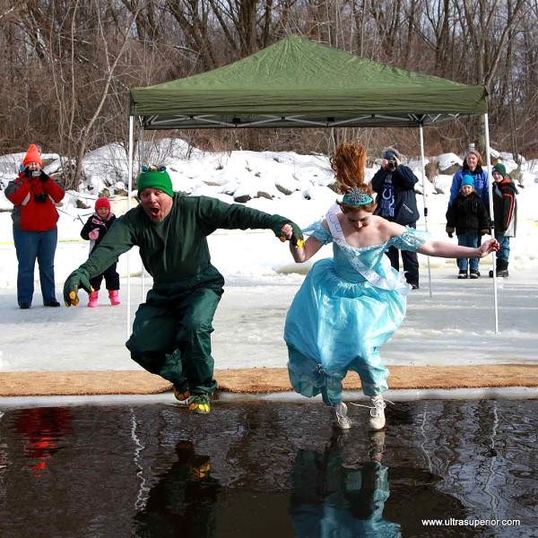 Annual tradition at Udder Snowshoe Race, Athens, WI: Queen dives in, sometimes with a helping hand.
