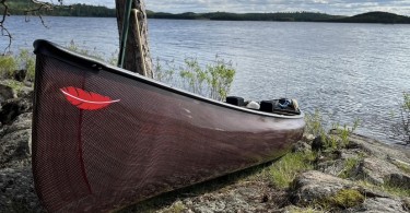 canoe sitting on the shore of a lake