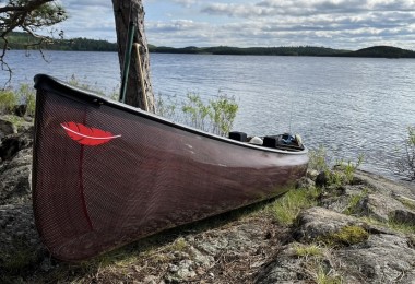 canoe sitting on the shore of a lake