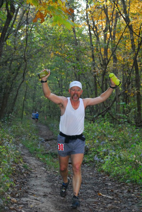 man with arms up running in Rock Bridge Revenge trail race