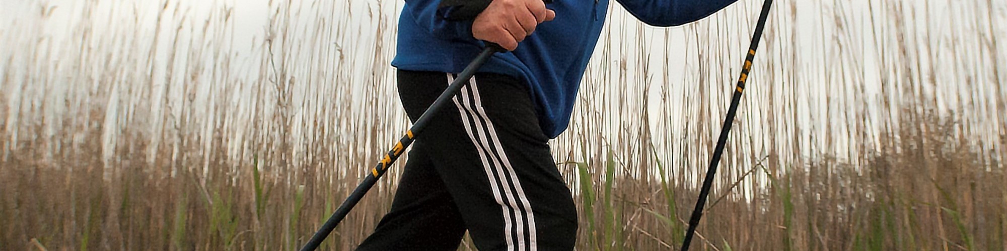 man using snowshoes and poles on sand