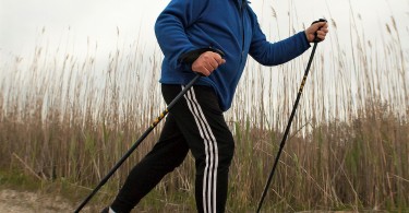 man using snowshoes and poles on sand