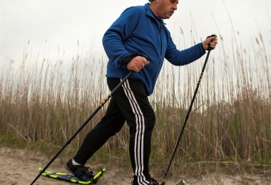 man using snowshoes and poles on sand