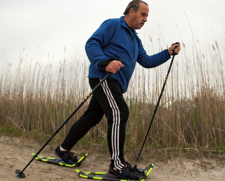 sandshoeing for WWF 5K: man using snowshoes and poles on sand