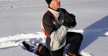 person demonstrating lunge on snowshoes in the snow