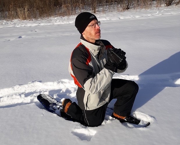 person demonstrating lunge on snowshoes in the snow