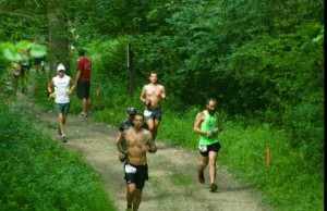 Chukuske Running into Daylight at the Afton 50km, Afton, Minn, flashing his tattoos. The ink represents he told me different periods of his life including personality and interests. Sometime ask him to explain their meaning; at least three are running related.