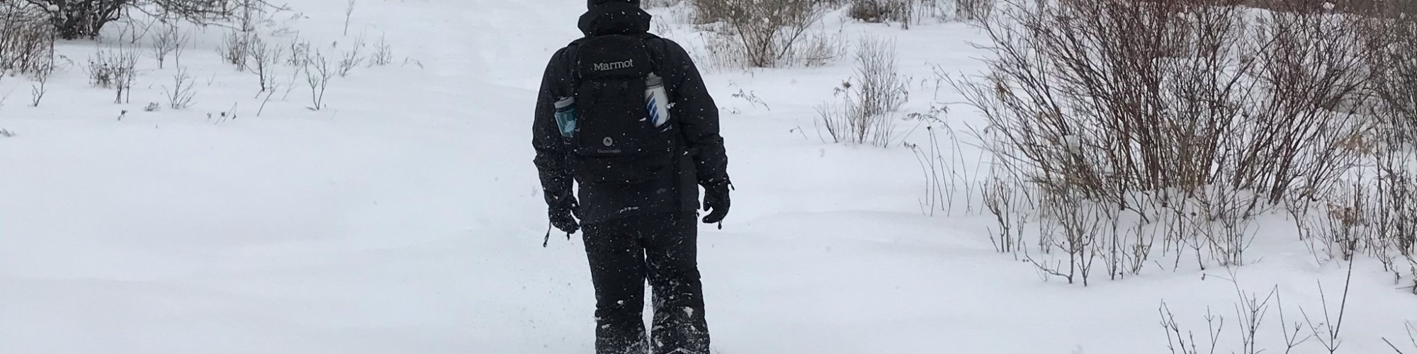 man snowshoeing in deep snow with Dion 164 snowshoes