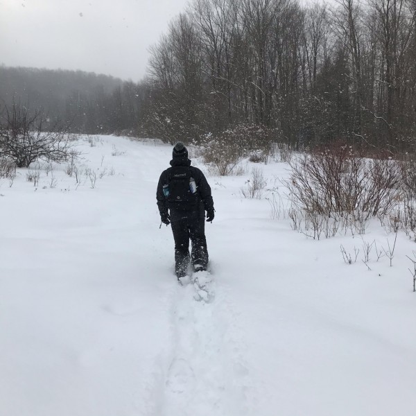 man snowshoeing in deep snow with Dion 164 snowshoes