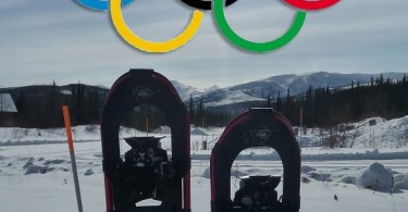 snowshoes sticking up in snow with Olympic rings above them