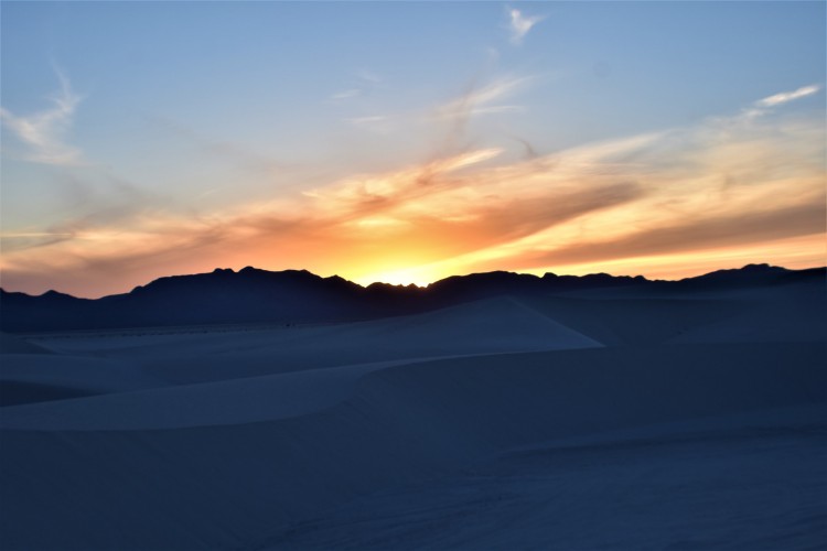 orange sunset behind White Sands National Park in NM