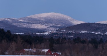 view of a lodge in distance with snowy hill in background