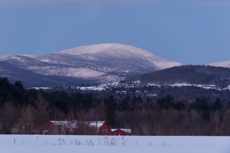 view of a lodge in distance with snowy hill in background