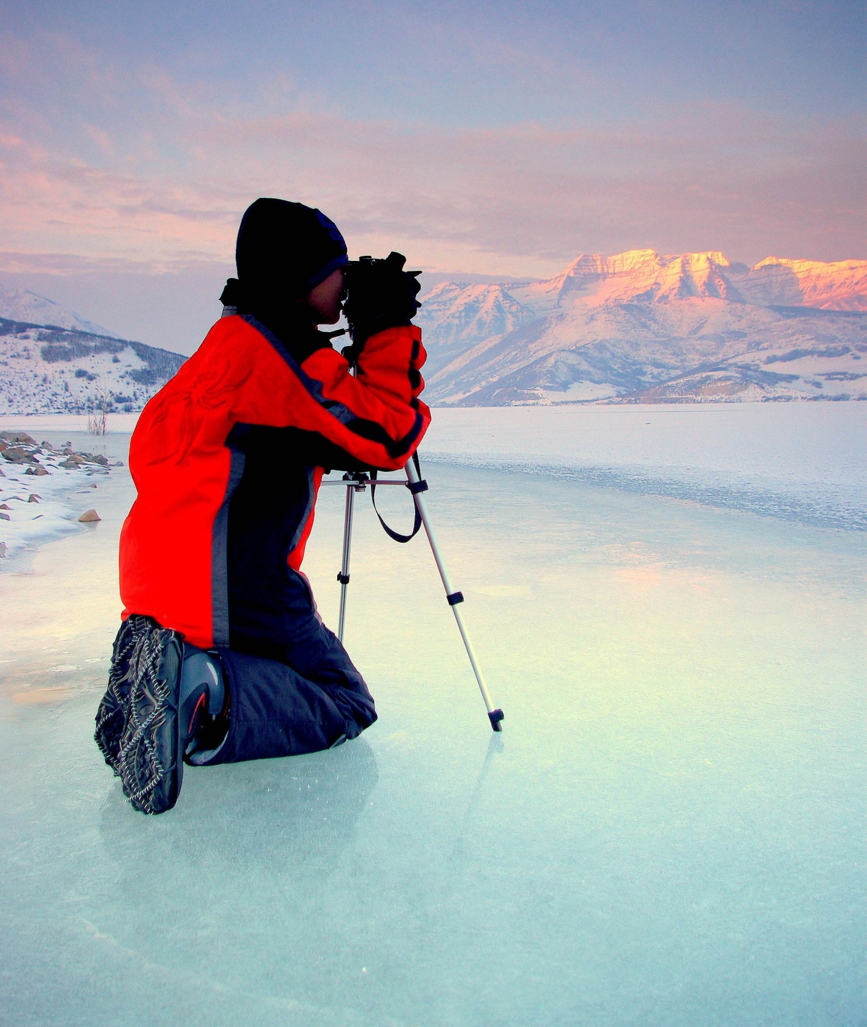 person with camera on lake, wearing Yaktrax traction device