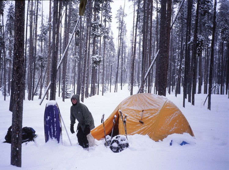 person at winter camp site in deep snow